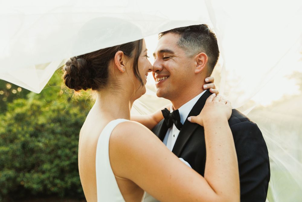 Romantic wedding portrait with couple sharing intimate moment against blurred background.