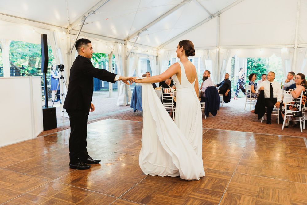 Couple dancing on a wooden floor during their wedding reception.