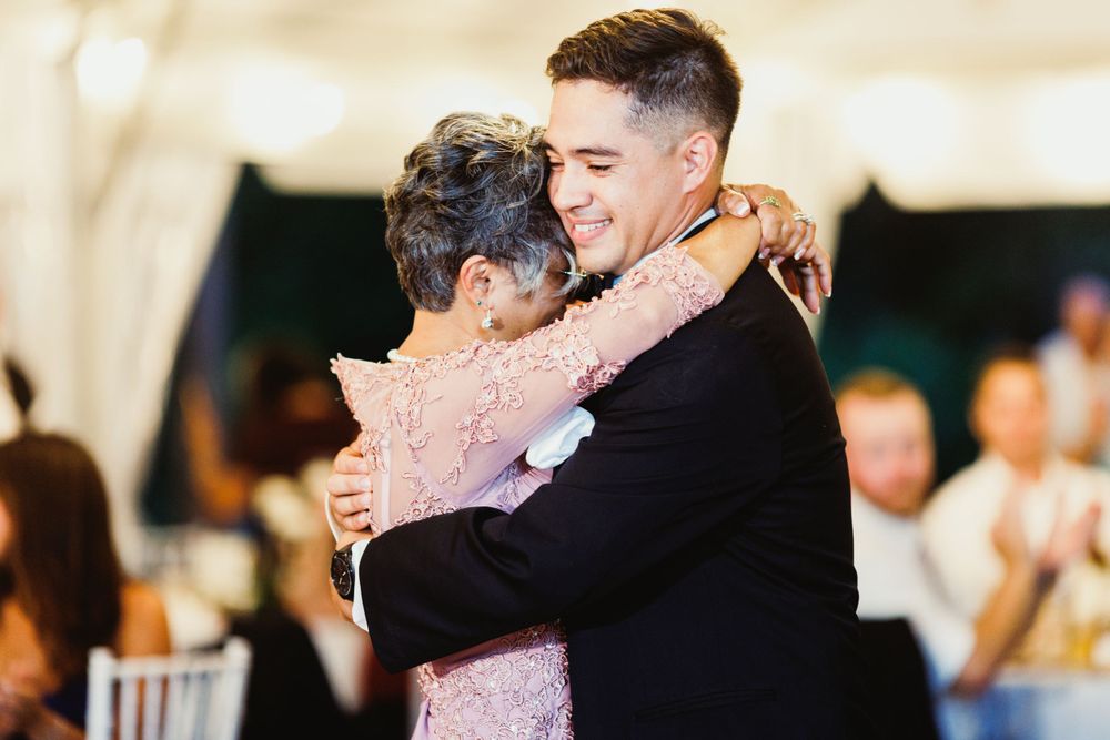 Intimate dance moment captured at wedding reception under tent lighting.