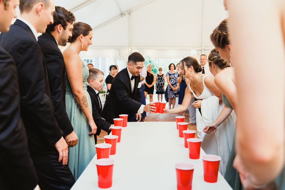 Wedding party playing a fun game with red cups at the reception.