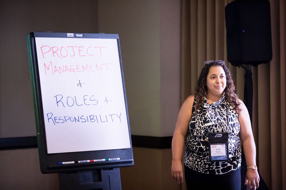 Professional development session with a whiteboard showing project management topics.