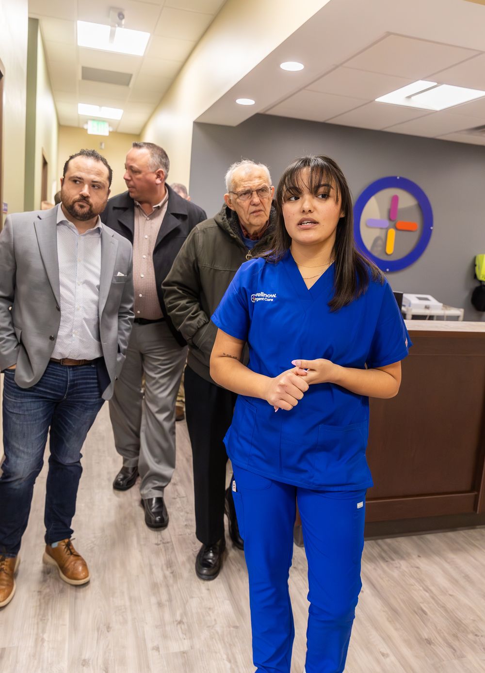 Medical staff and visitors touring a new healthcare facility with modern interior design.