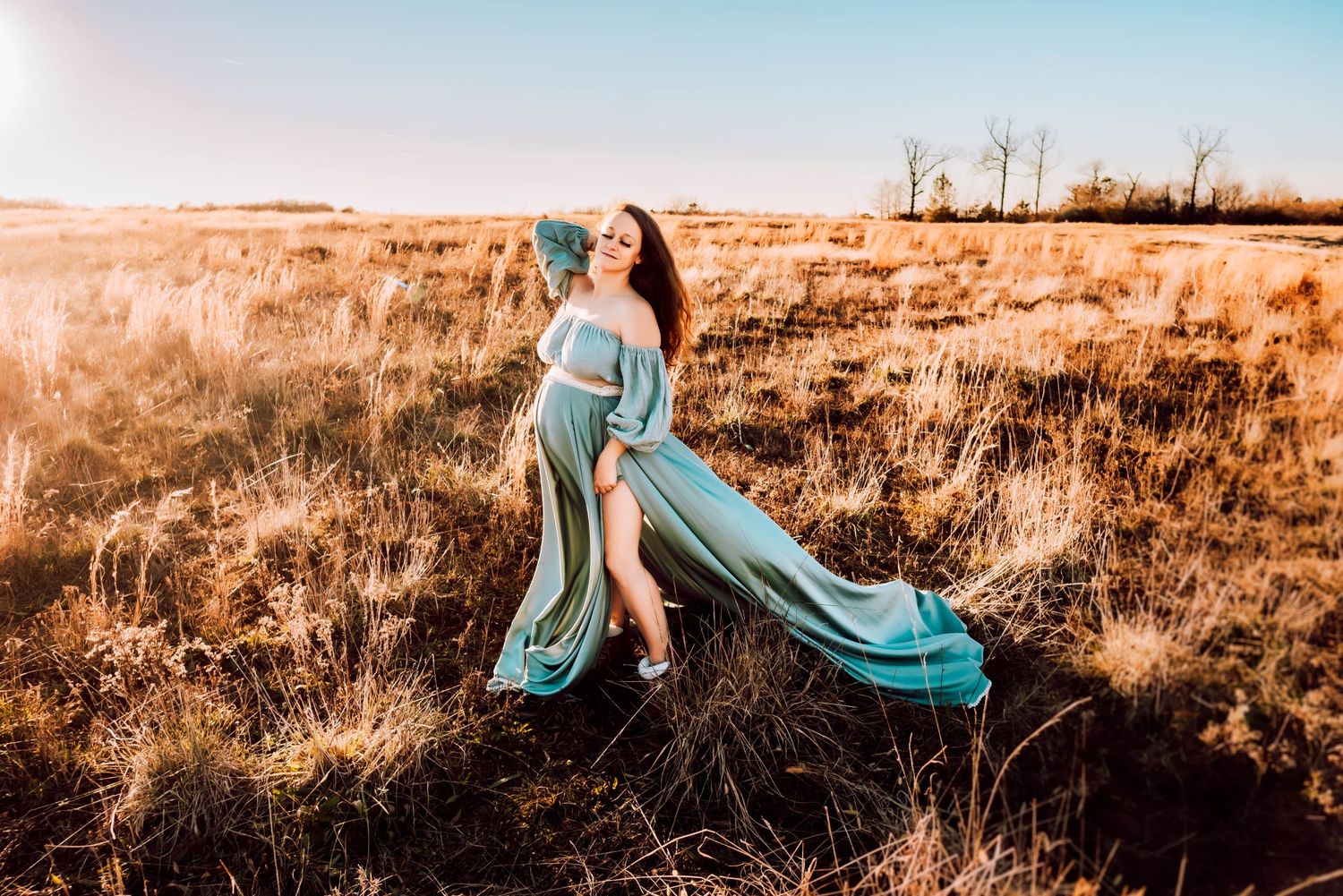 Artistic outdoor portrait session in a sun-drenched field with teal accents.