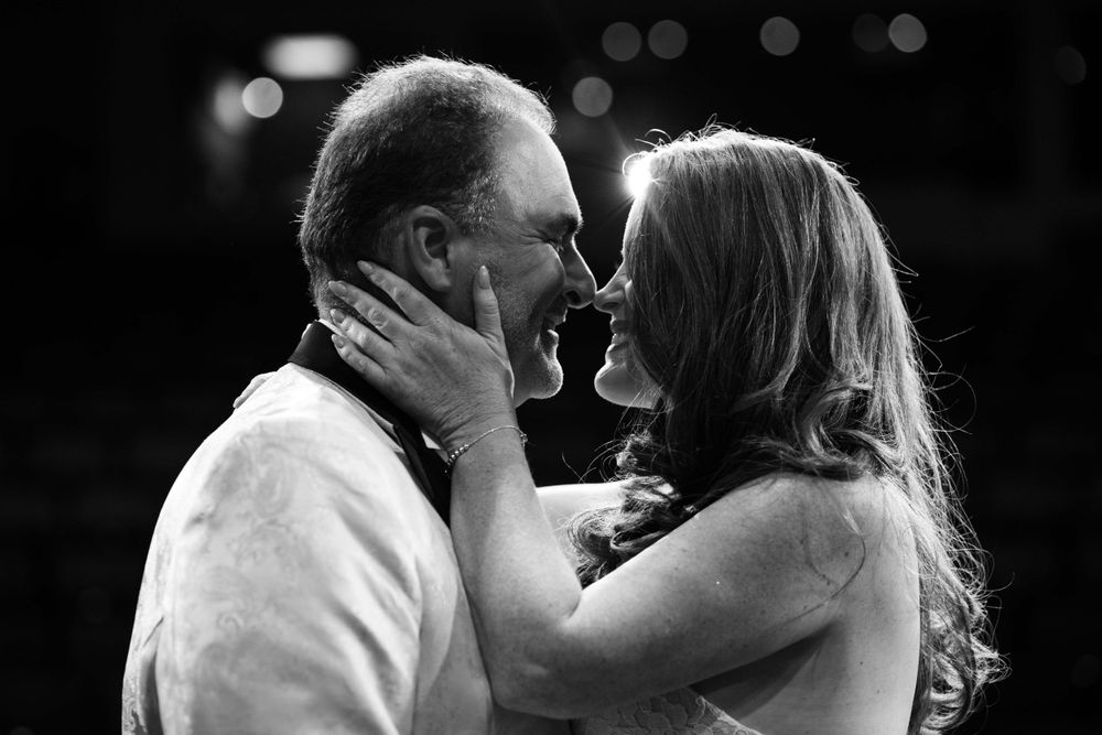 Black and White Bride and groom pose on a performing arts stage under theatrical lighting, captured by Chris Cornish Photography.