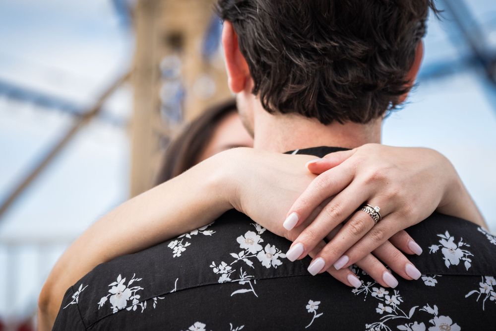 Engaged couple smiles together at the Balboa Fun Zone in Balboa, California. Captured by Chris Cornish Photography.