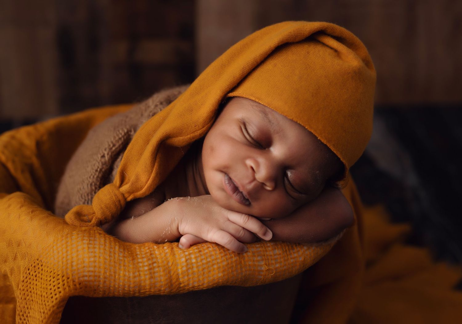 Sleeping baby wrapped in cozy mustard yellow knit blanket.