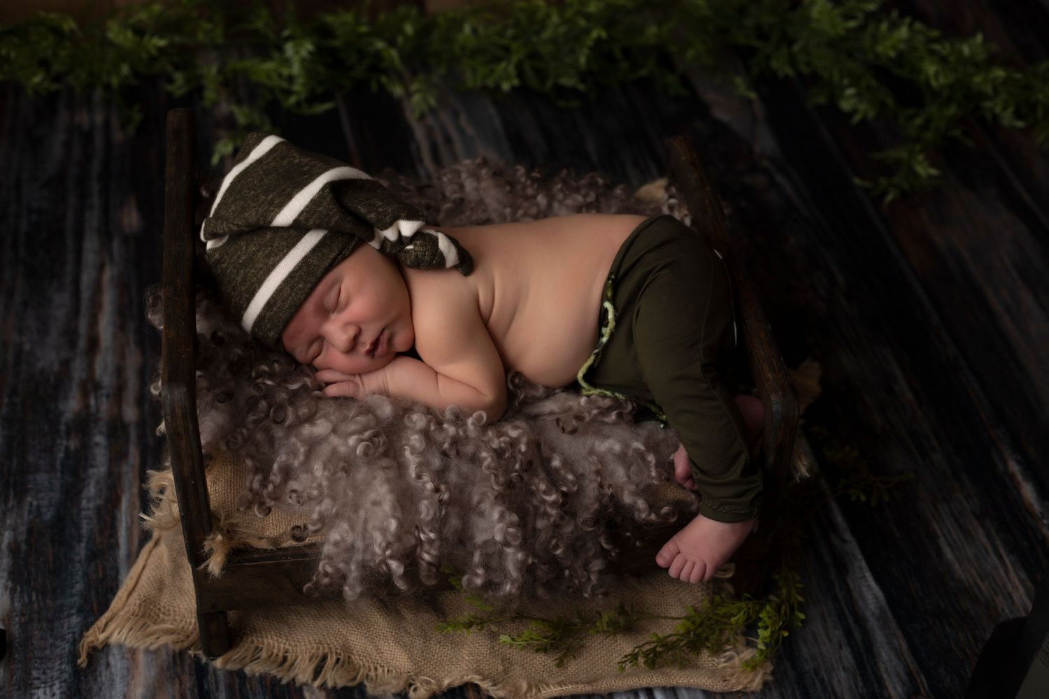 Rustic newborn photography featuring natural textures and dark moody lighting.