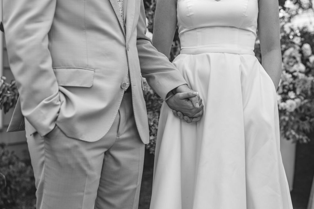 Minimalist black and white photo showing wedding couple's formal attire details.