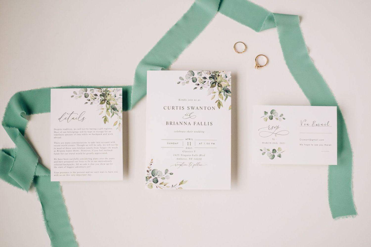 wedding invitation suite with green ribbon and gold rings