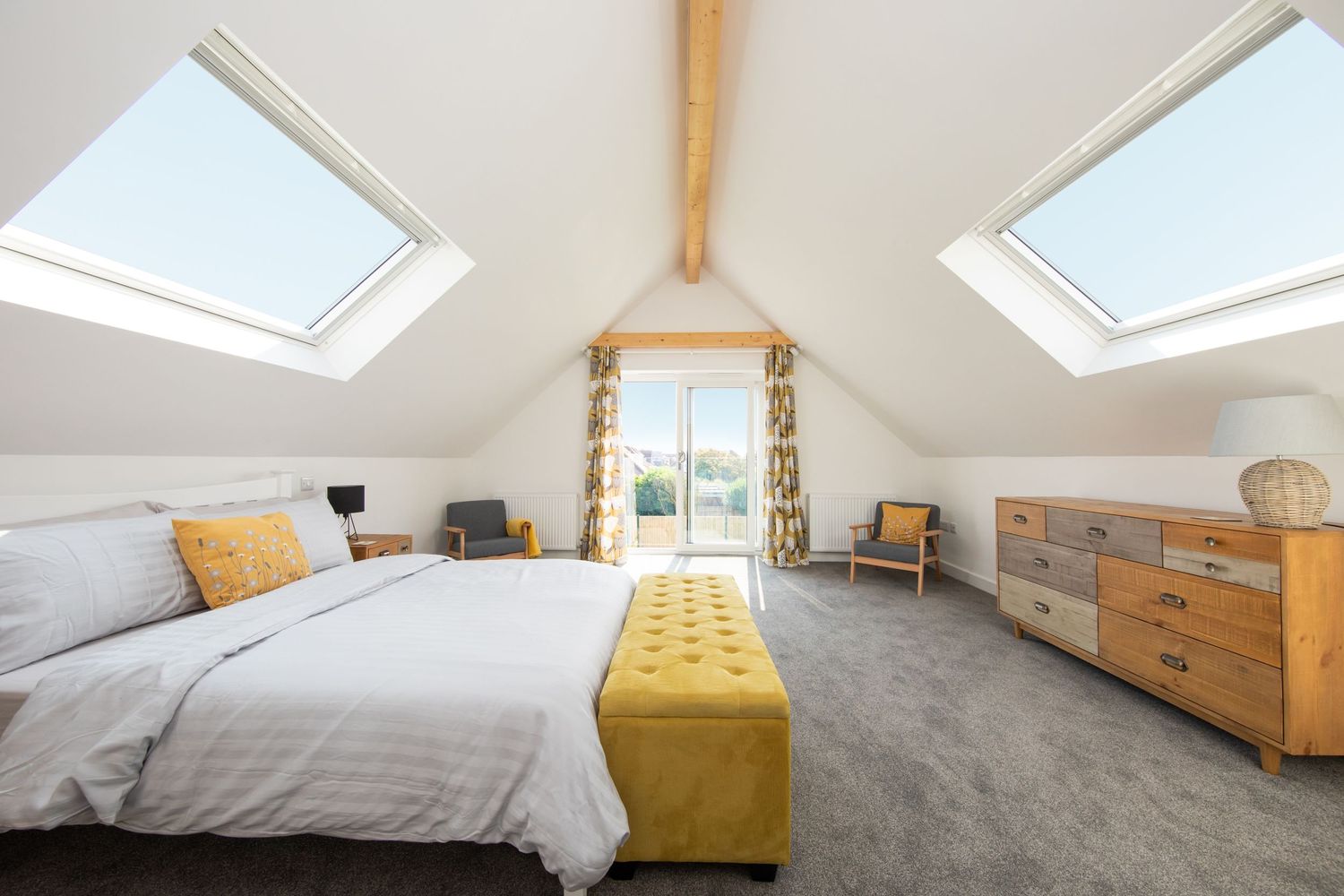 Luxurious bedroom with skylights and yellow accents featuring ocean views.