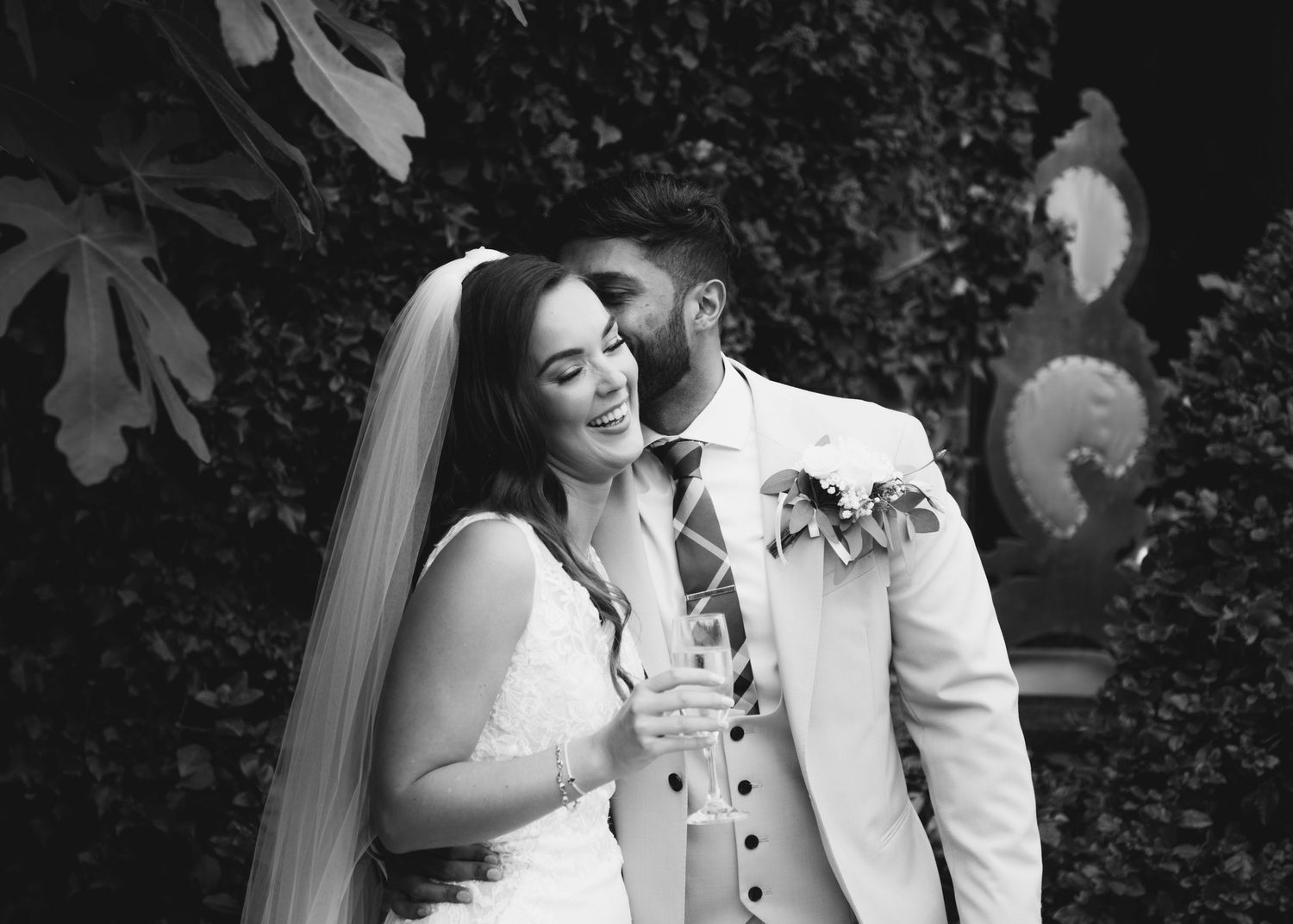 West Midlands wedding photographer capturing a tender moment as groom kisses bride on the cheek