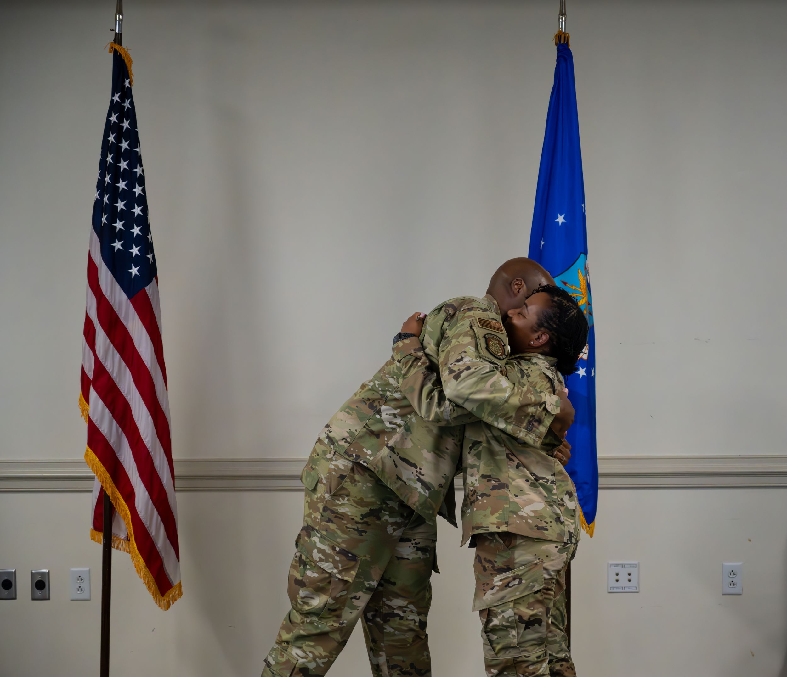 Service members embrace during emotional military ceremony moment.