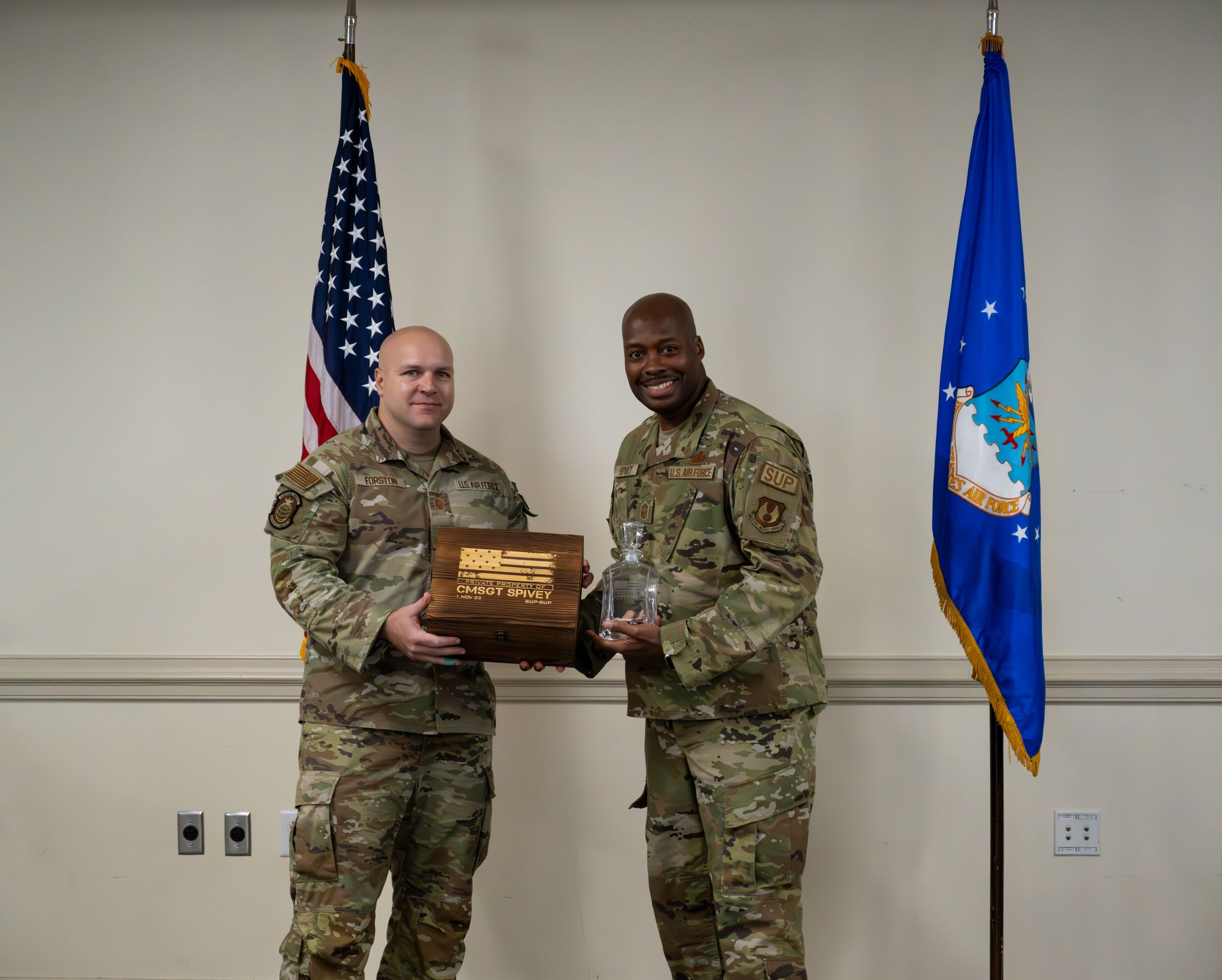 Military members hold ceremonial plaque during official presentation.