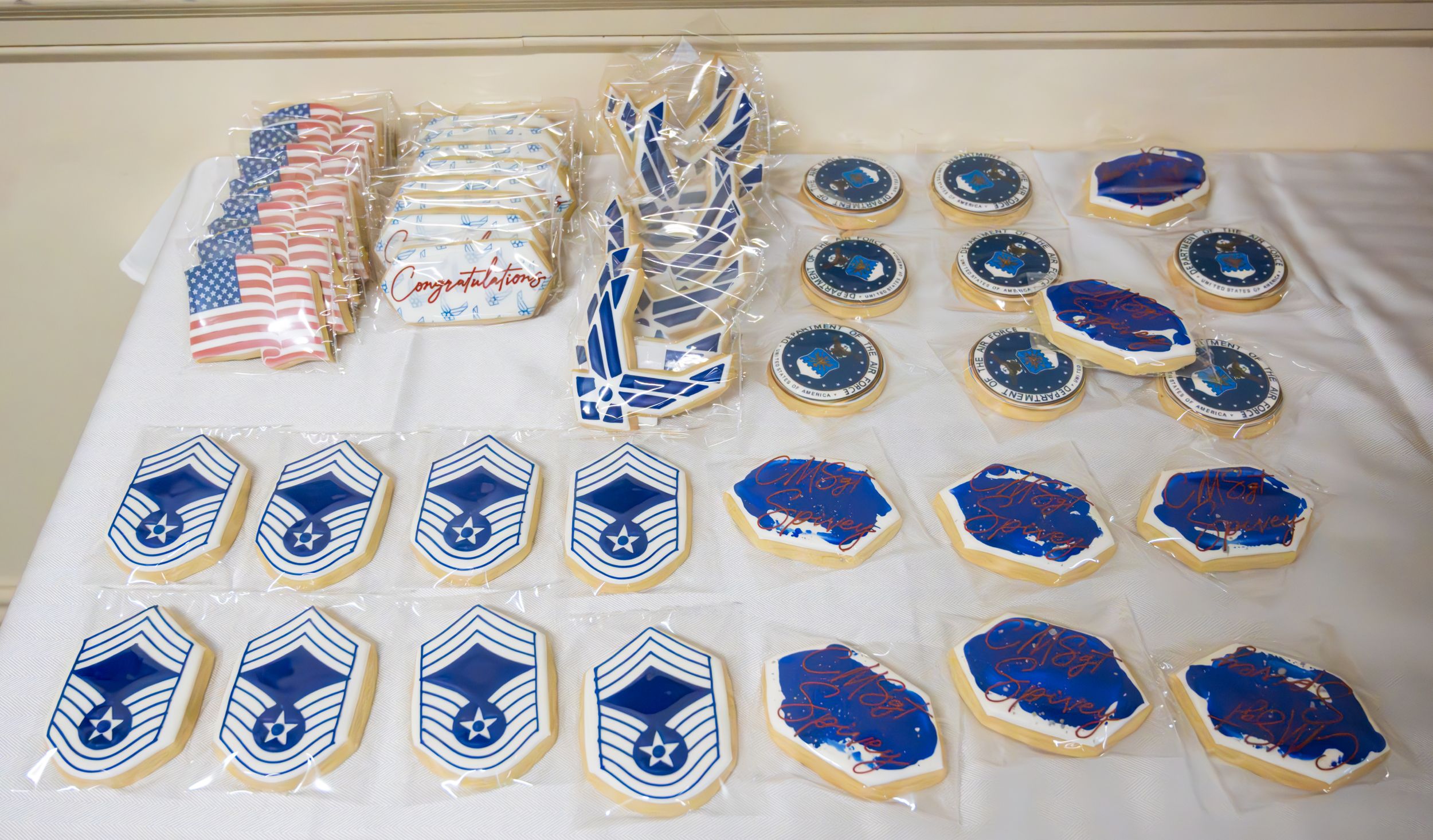 Display of military patches, ranks and insignia laid out on white table.