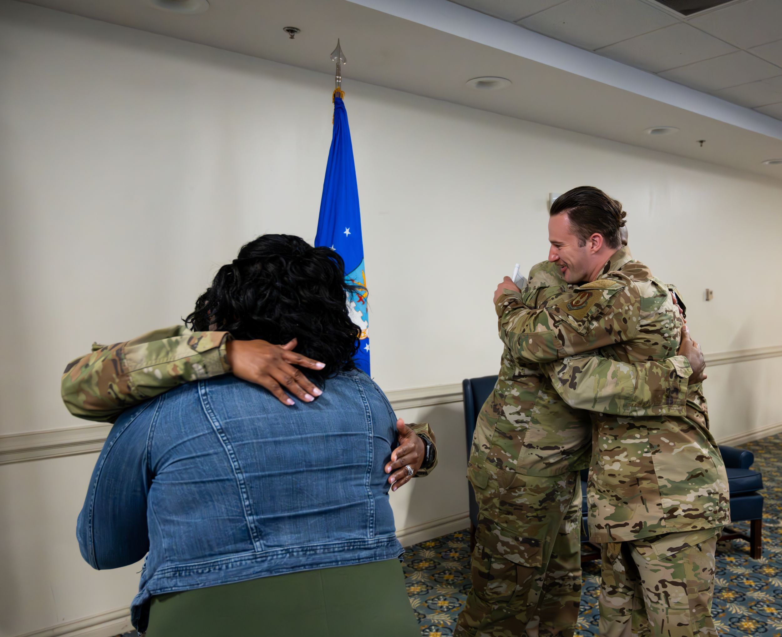Military personnel sharing emotional embraces during ceremony.