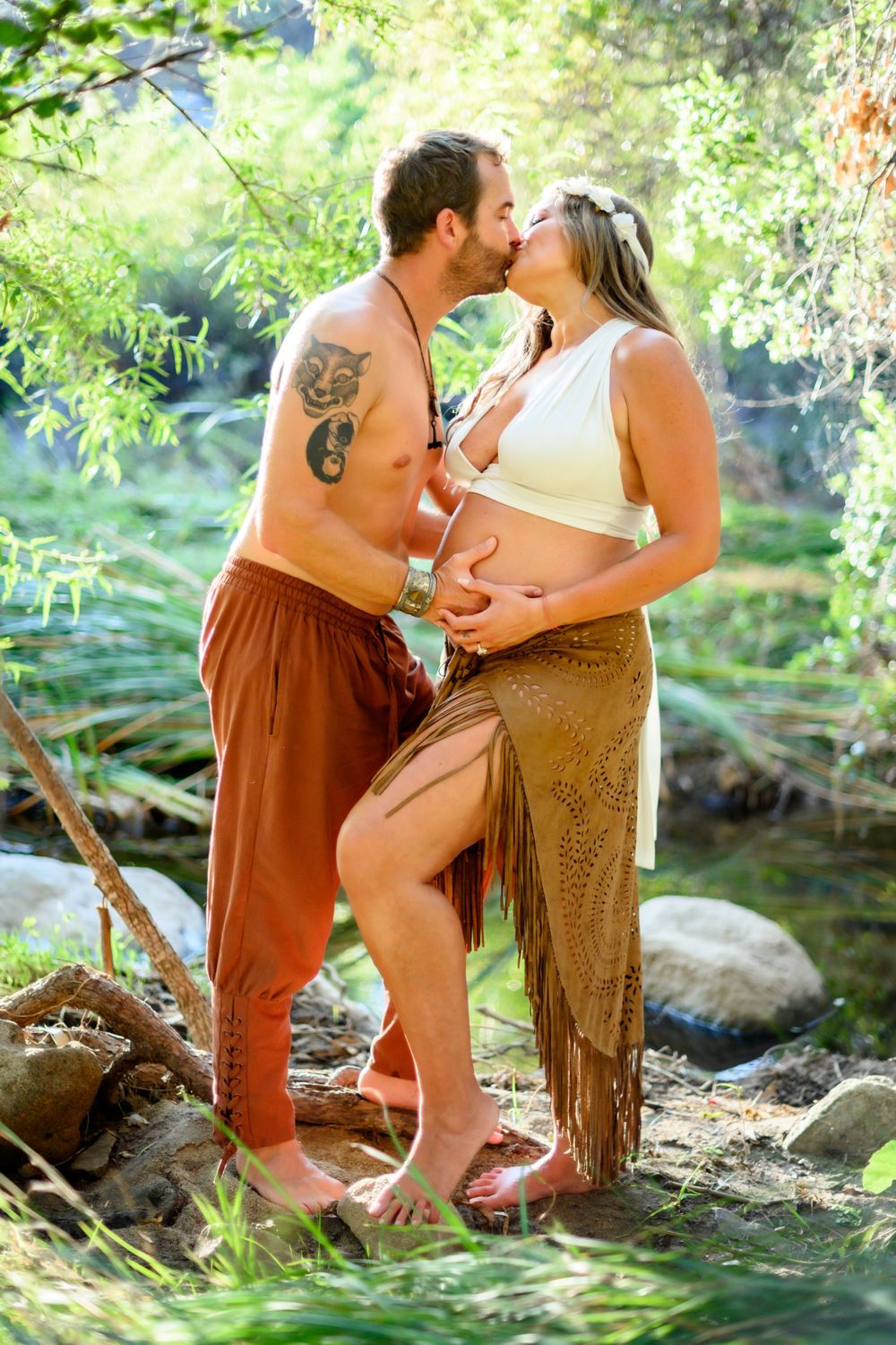 Intimate bohemian maternity photo of couple barefoot by a creek. Maternity photoshoot in Las Vegas. Maternity photographer Las Vegas.