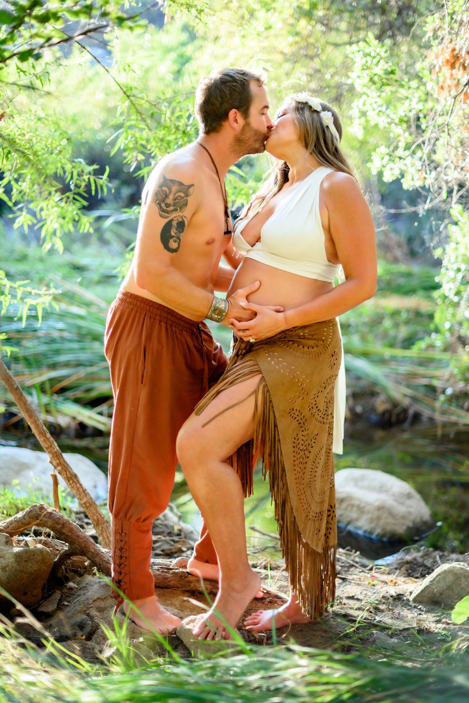 Intimate bohemian maternity photo of couple barefoot by a creek. Maternity photoshoot in Las Vegas. Maternity photographer Las Vegas.