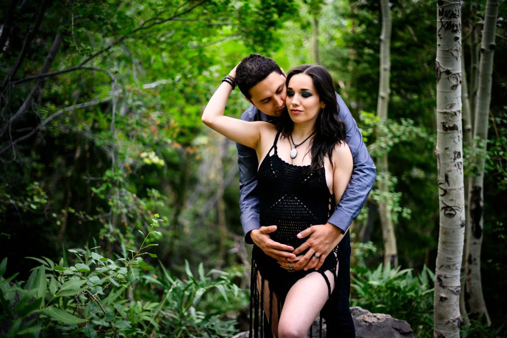 Romantic maternity portrait of couple embracing in forest setting. Maternity photoshoot in Las Vegas. Maternity photographer Las Vegas.