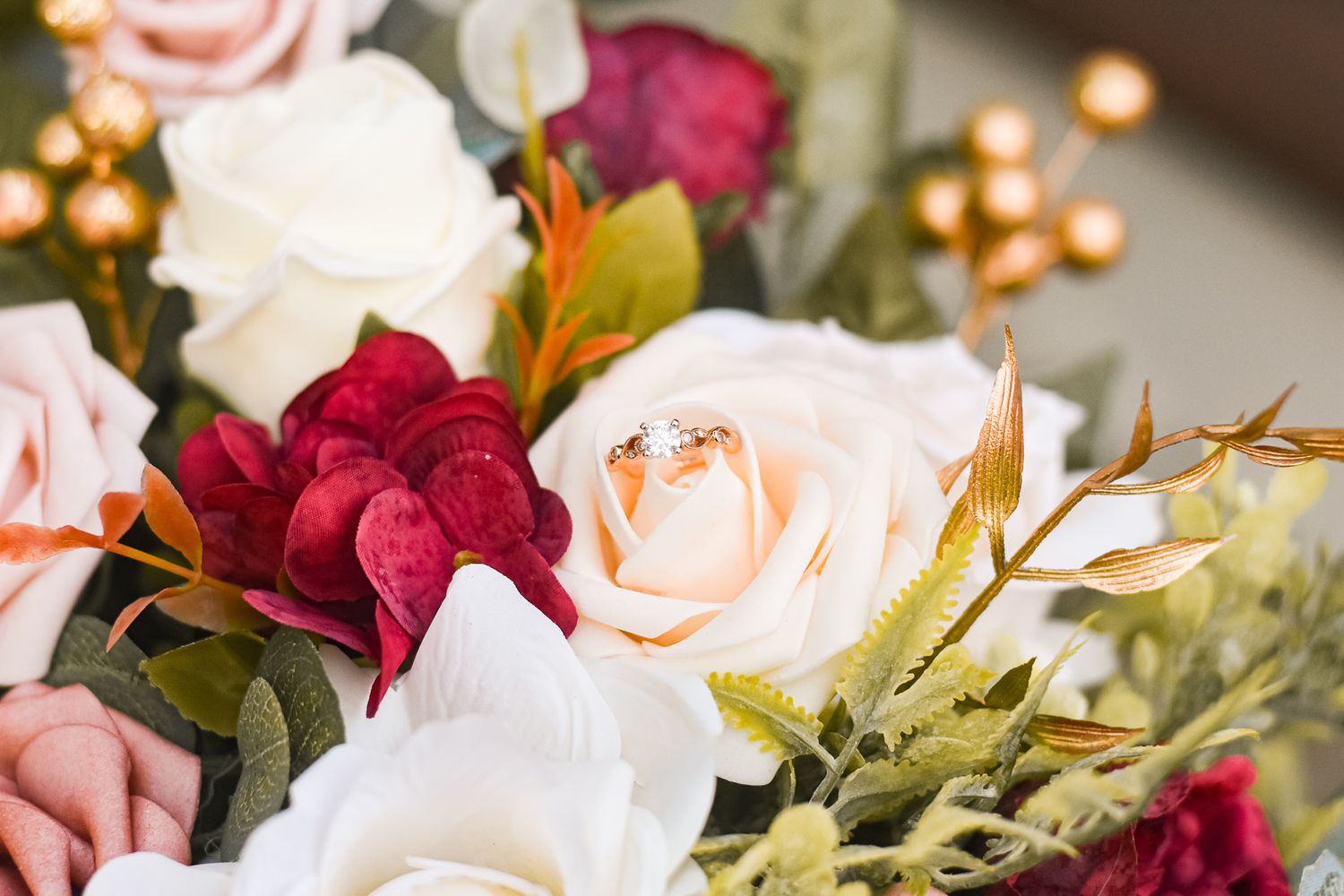 Beautiful wedding bouquet with pink and red roses mixed with greenery.