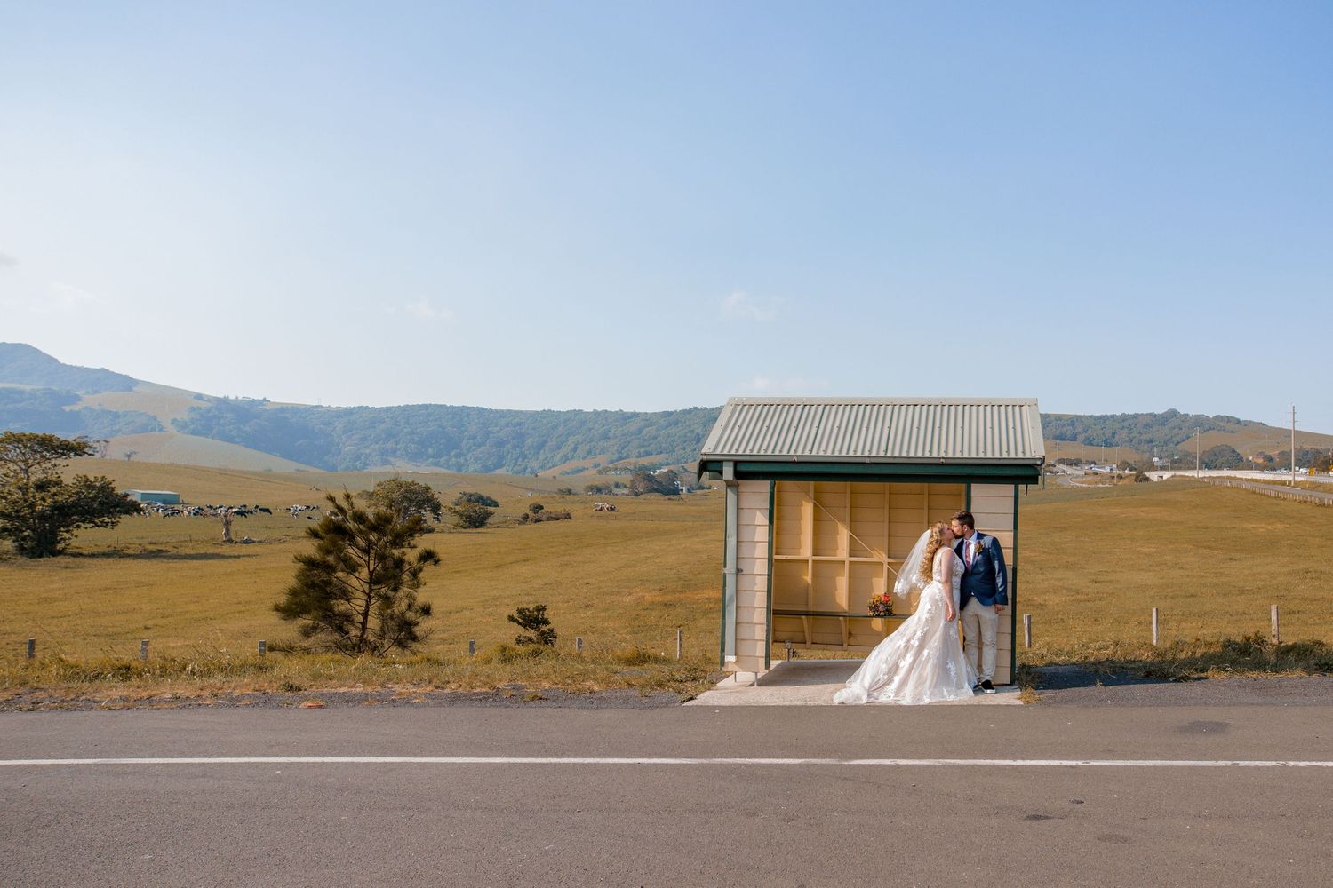 Couple kissing in a bus depot in Gerringong with the mountains behind them. Illawarra NSW