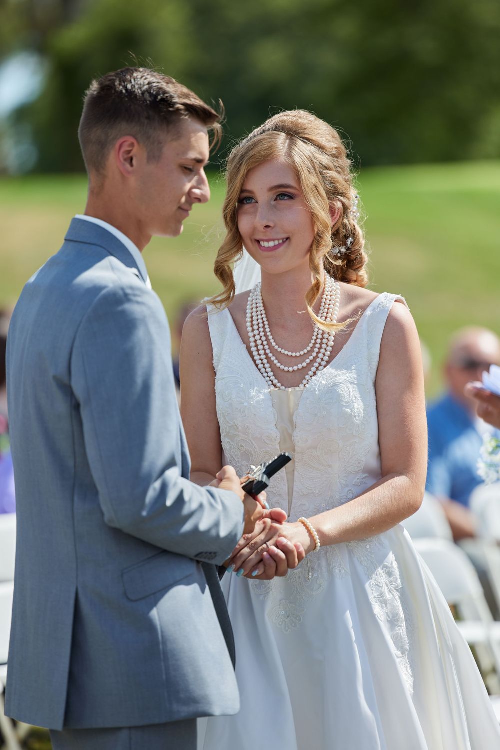 Bride and groom exchanging vows during outdoor wedding ceremony.