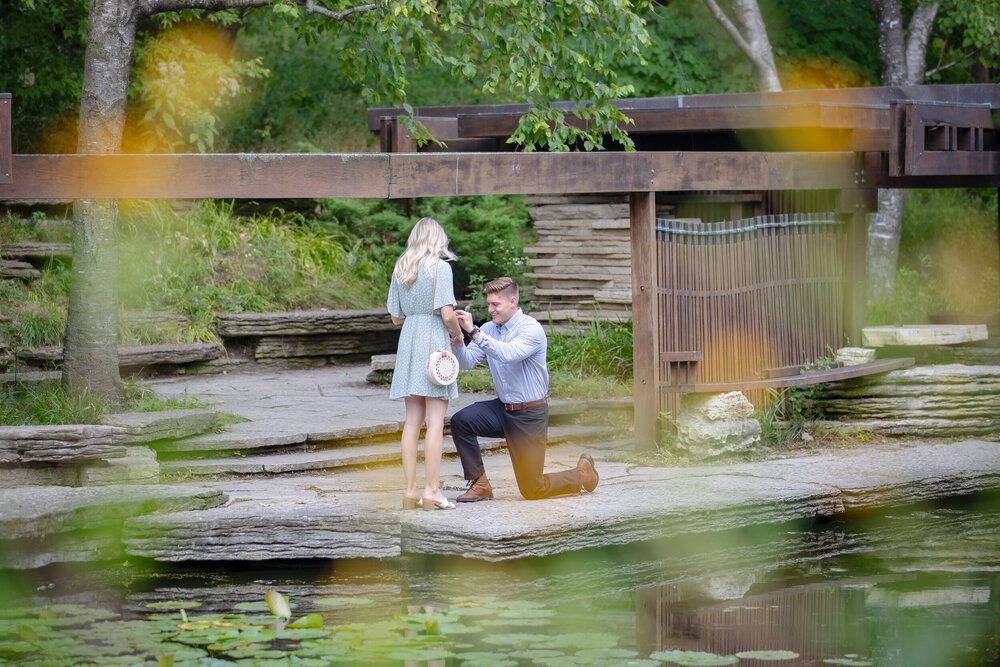 Couple shares tender moment on wooden boardwalk surrounded by nature.