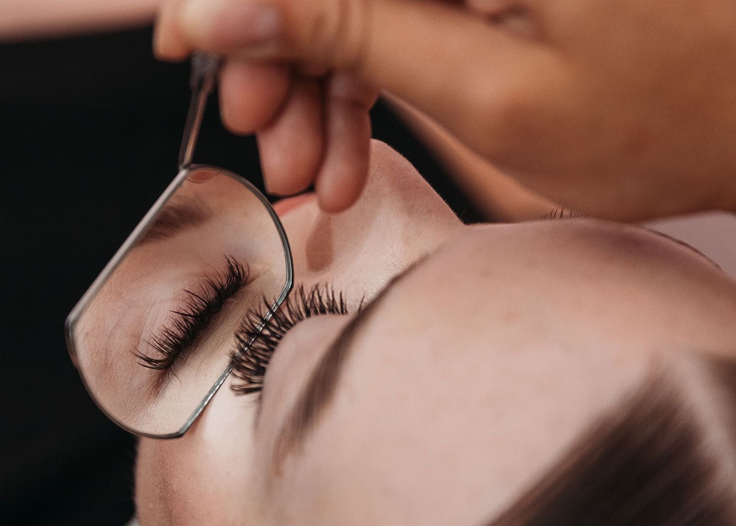 Close up of professional eyelash extension application process.