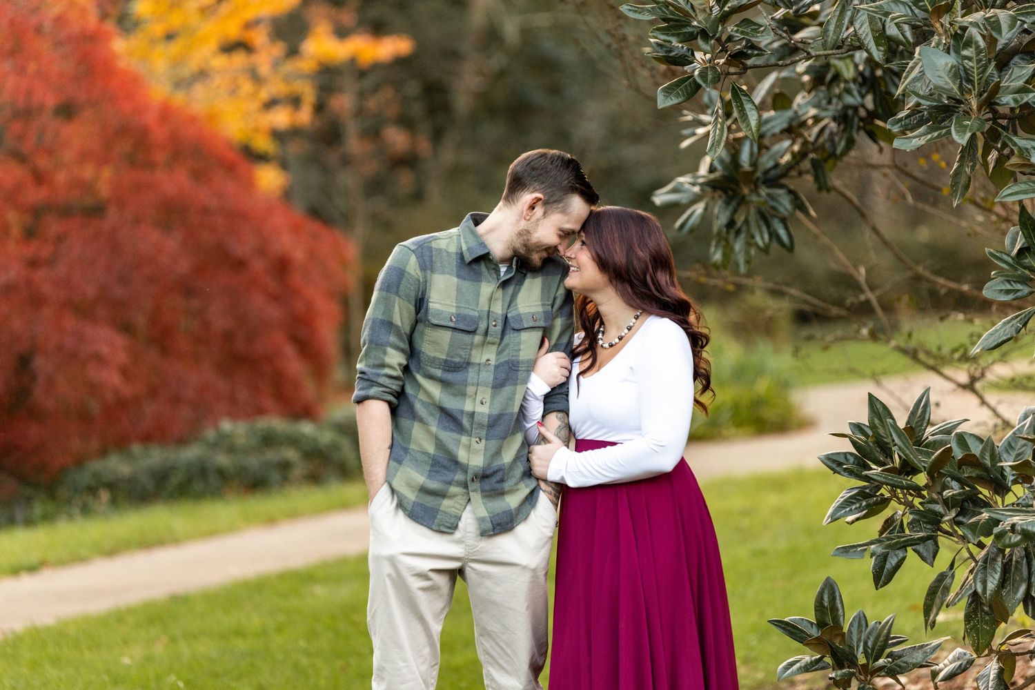 Romantic autumn portrait with fall foliage and soft intimate moment in garden setting.