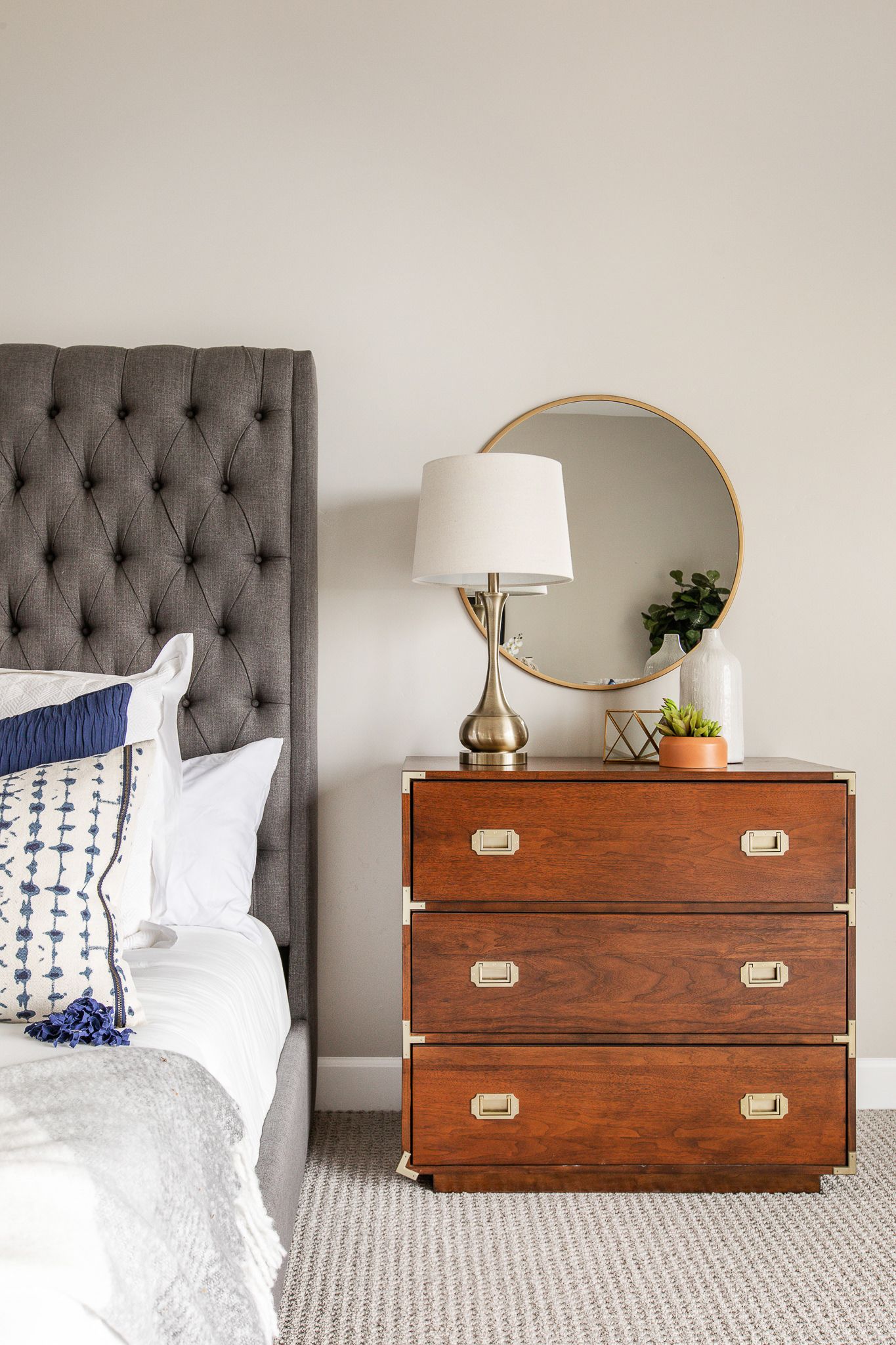 professional real estate photography - Bed with night stand, lamps and decor on the night stand with a mirror.