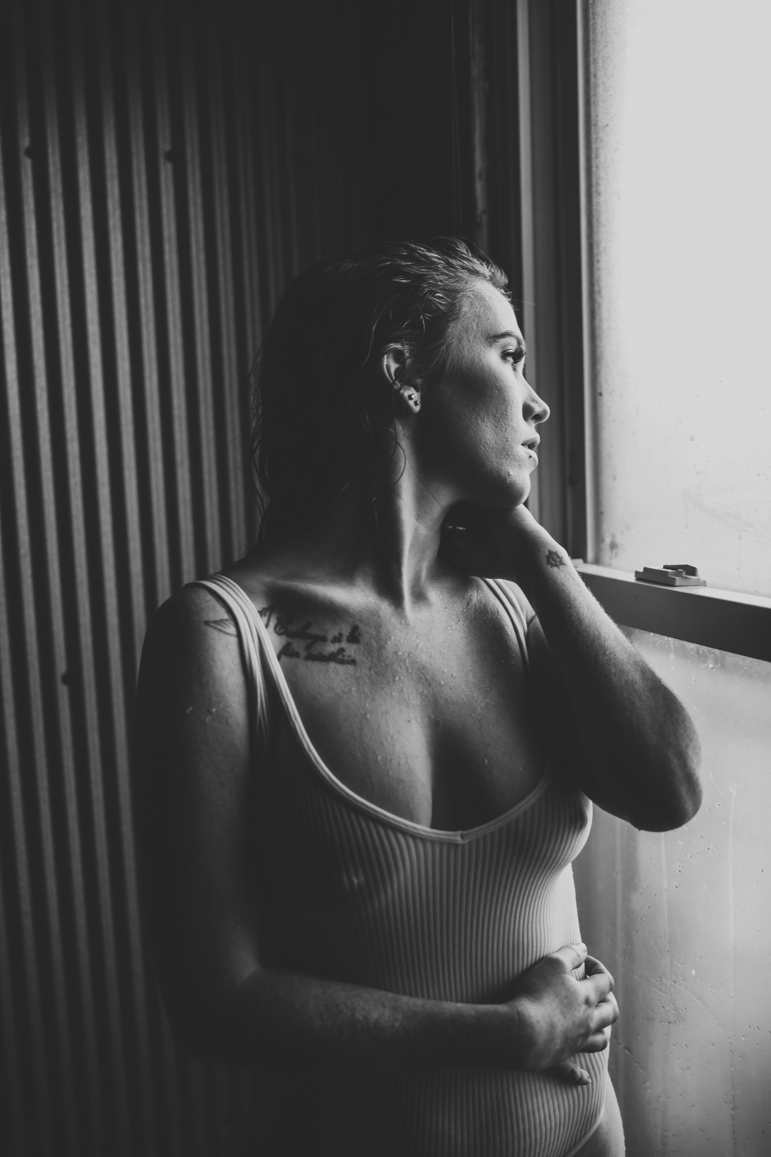 Moody black and white portrait series with dramatic window lighting and shadows.