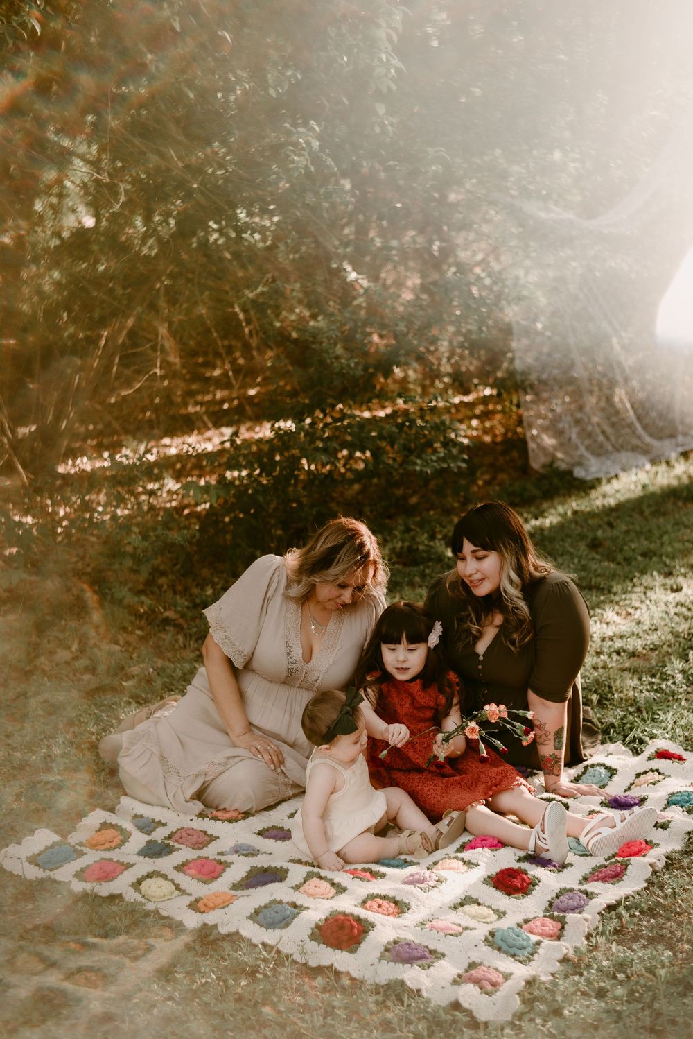 An intimate gathering moment captured on a vintage quilt in golden afternoon light.