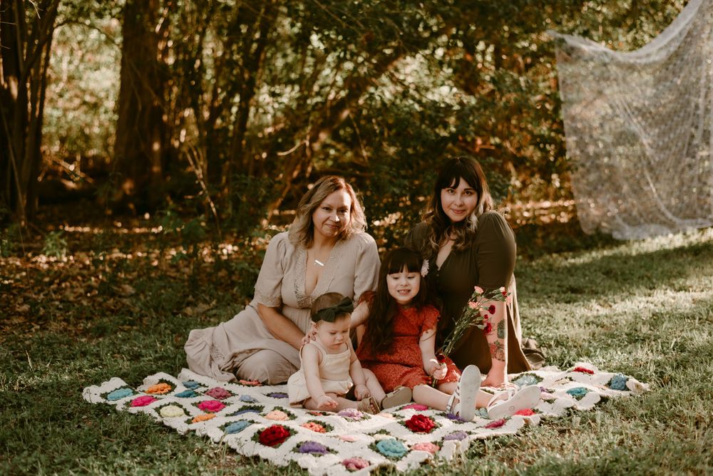 A cozy autumn picnic scene with a decorative quilt spread on grass.
