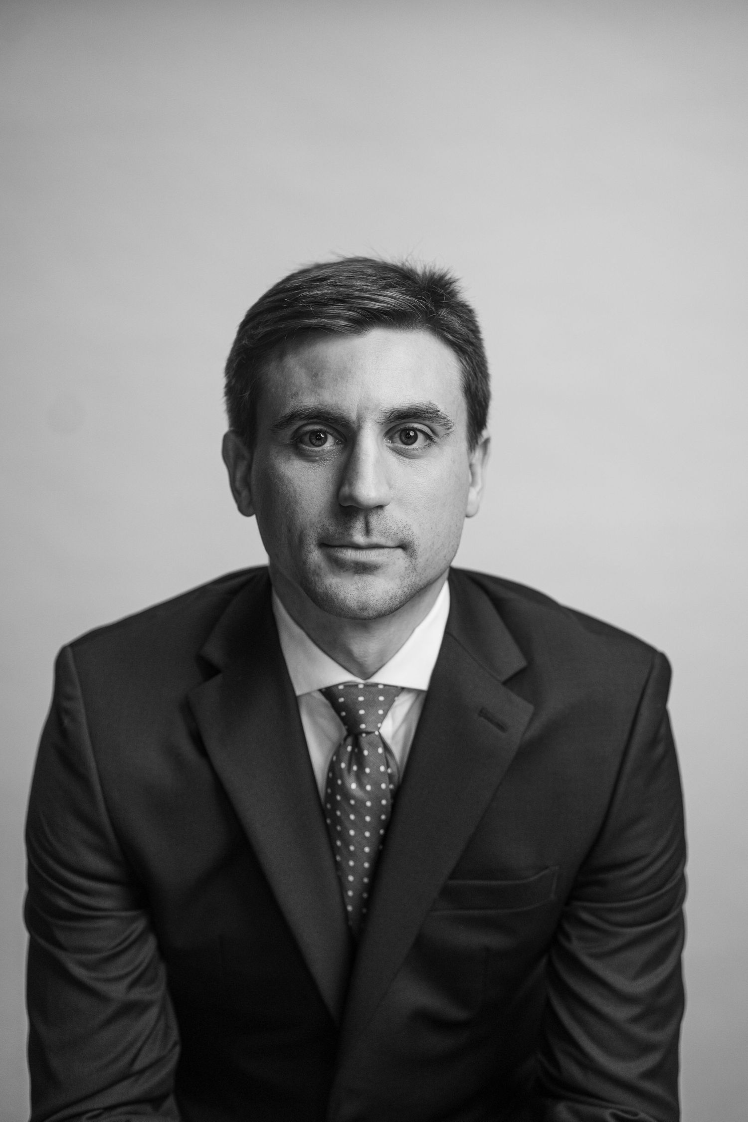 Professional black and white studio portrait of businessman in formal attire.