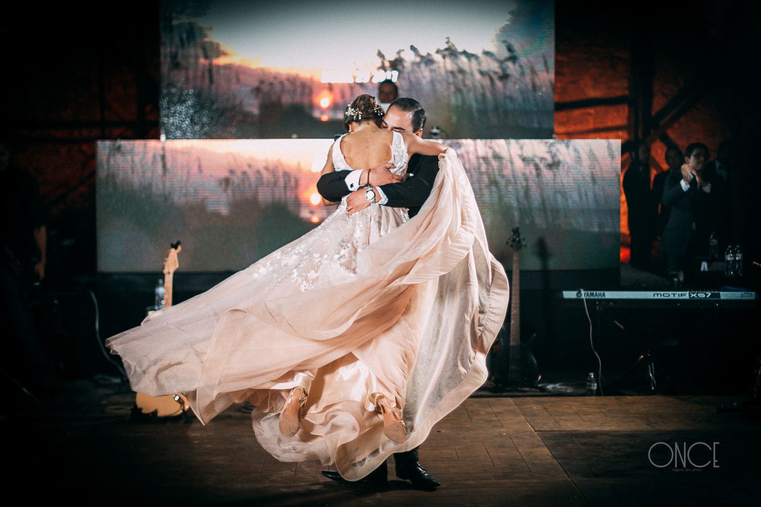 A dramatic dance dip with flowing wedding dress during a reception.