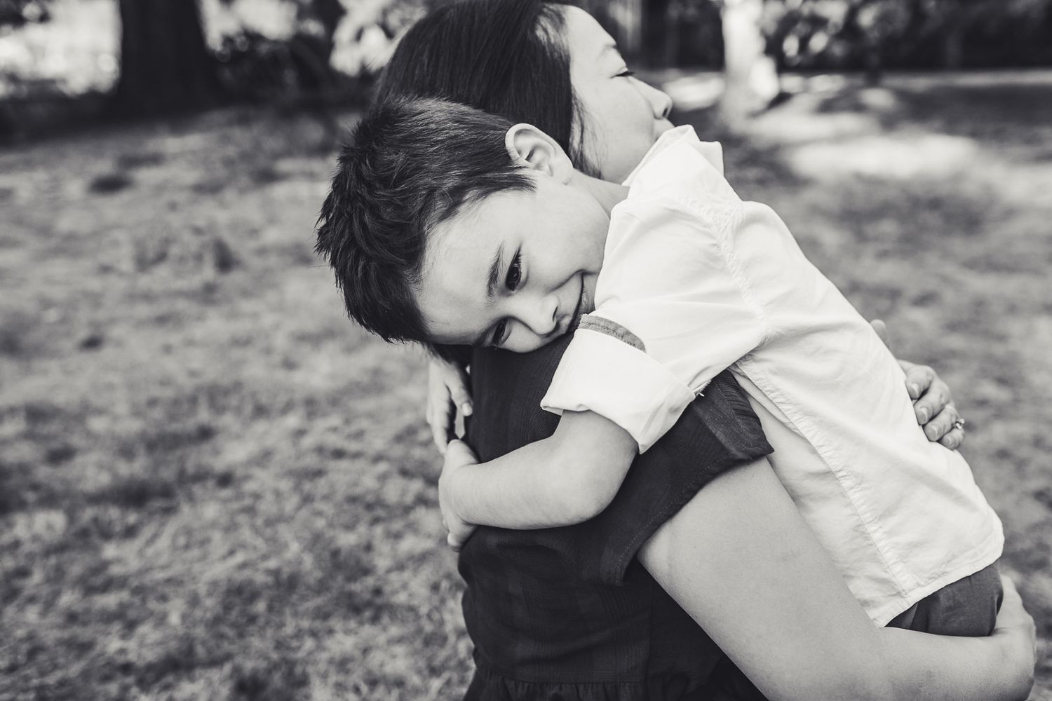 Black and white candid photo of son tenderly embracing mother