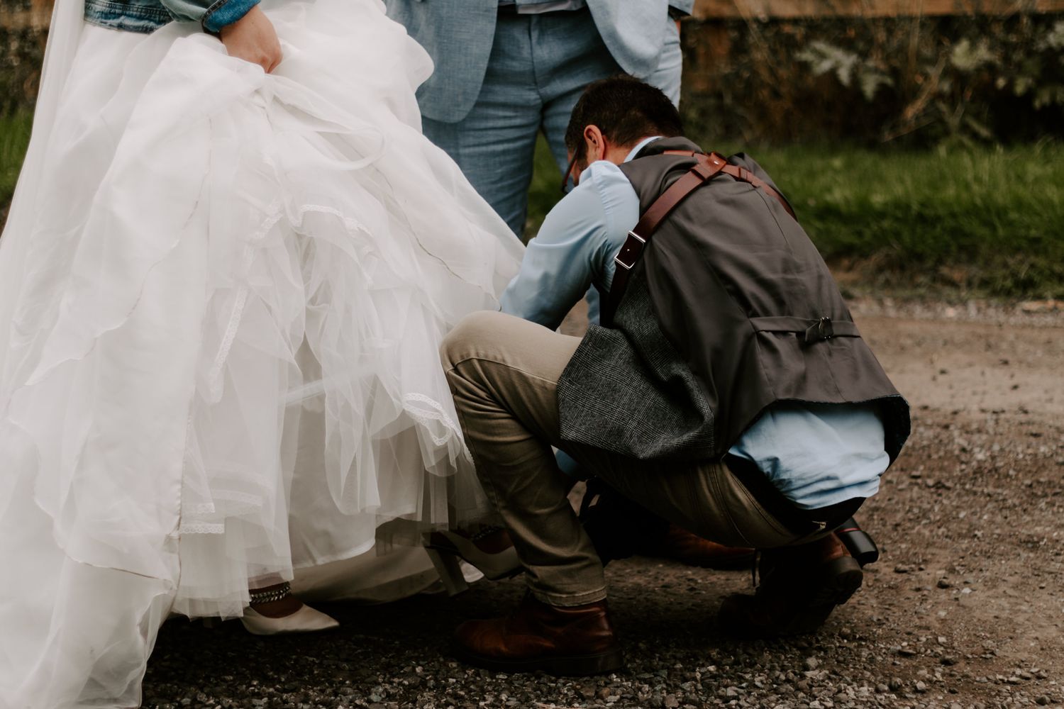 photographer helping bride with shoes