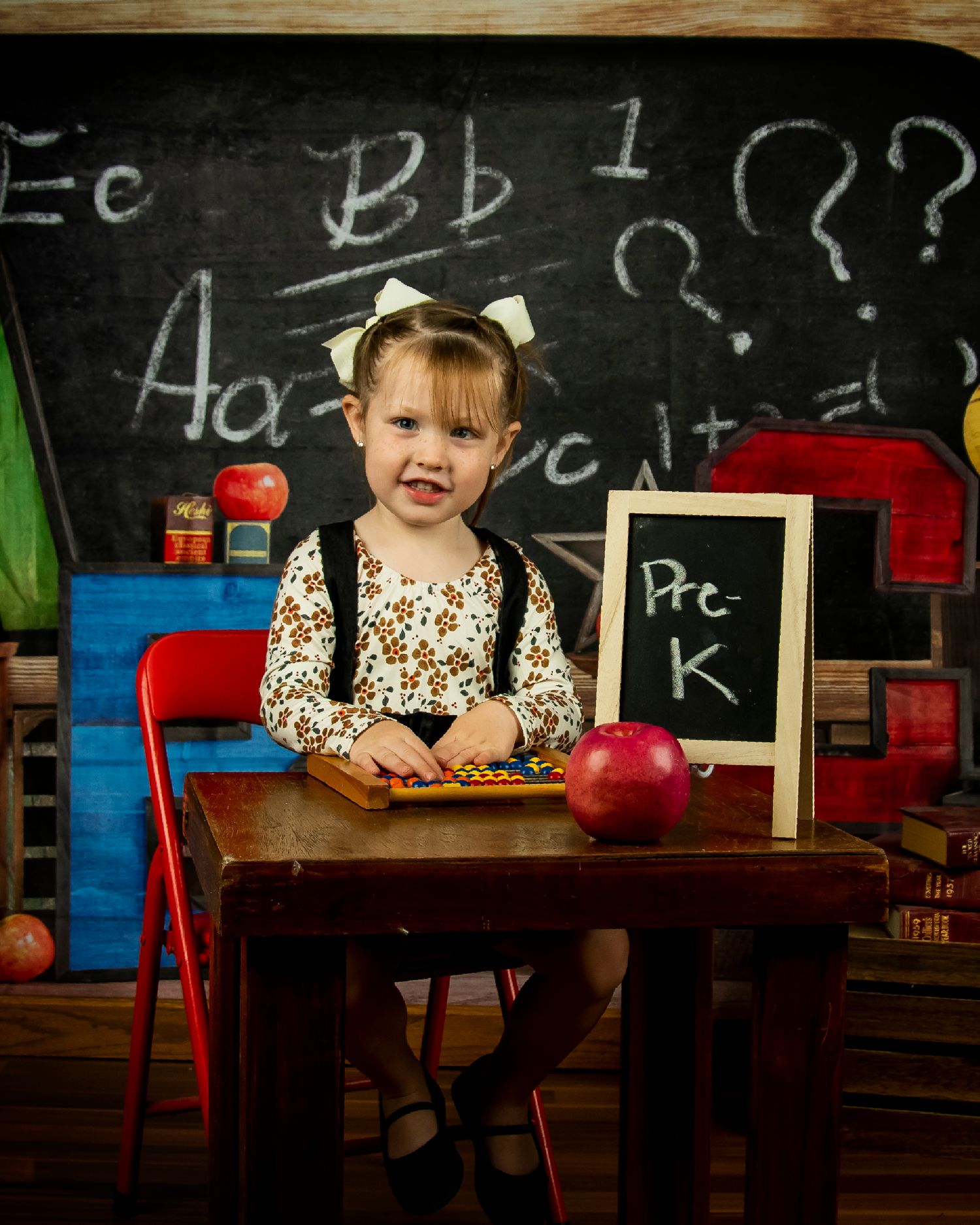Classic school desk setup with chalkboard, apple, and educational props.