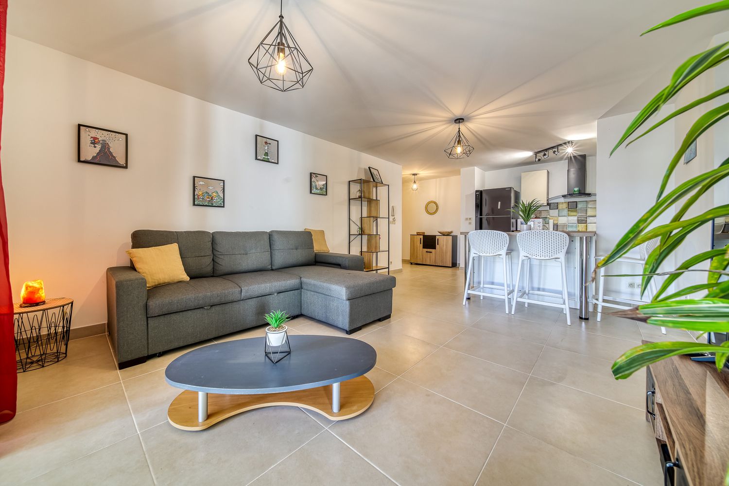 Spacious modern living area with grey sectional sofa and open floor plan.