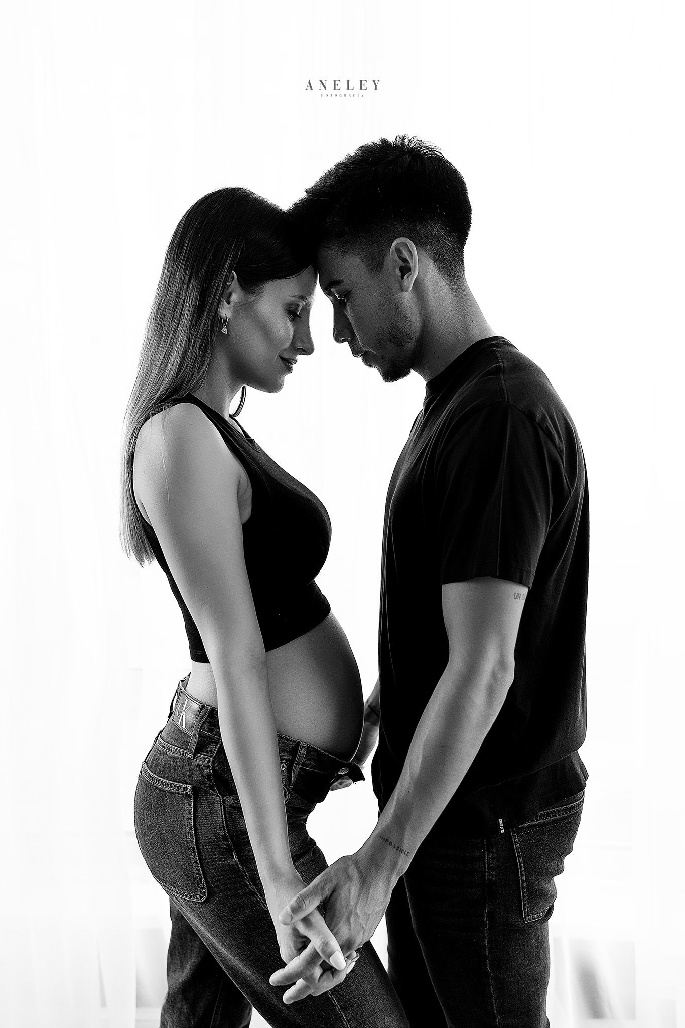 Artistic black and white maternity portrait showing intimate moment between expecting couple.