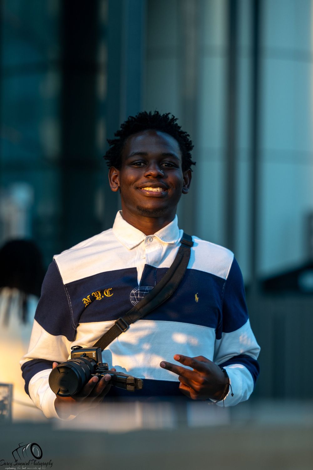 Student in navy blue and white uniform reads from a book during outdoor study session at sunset.