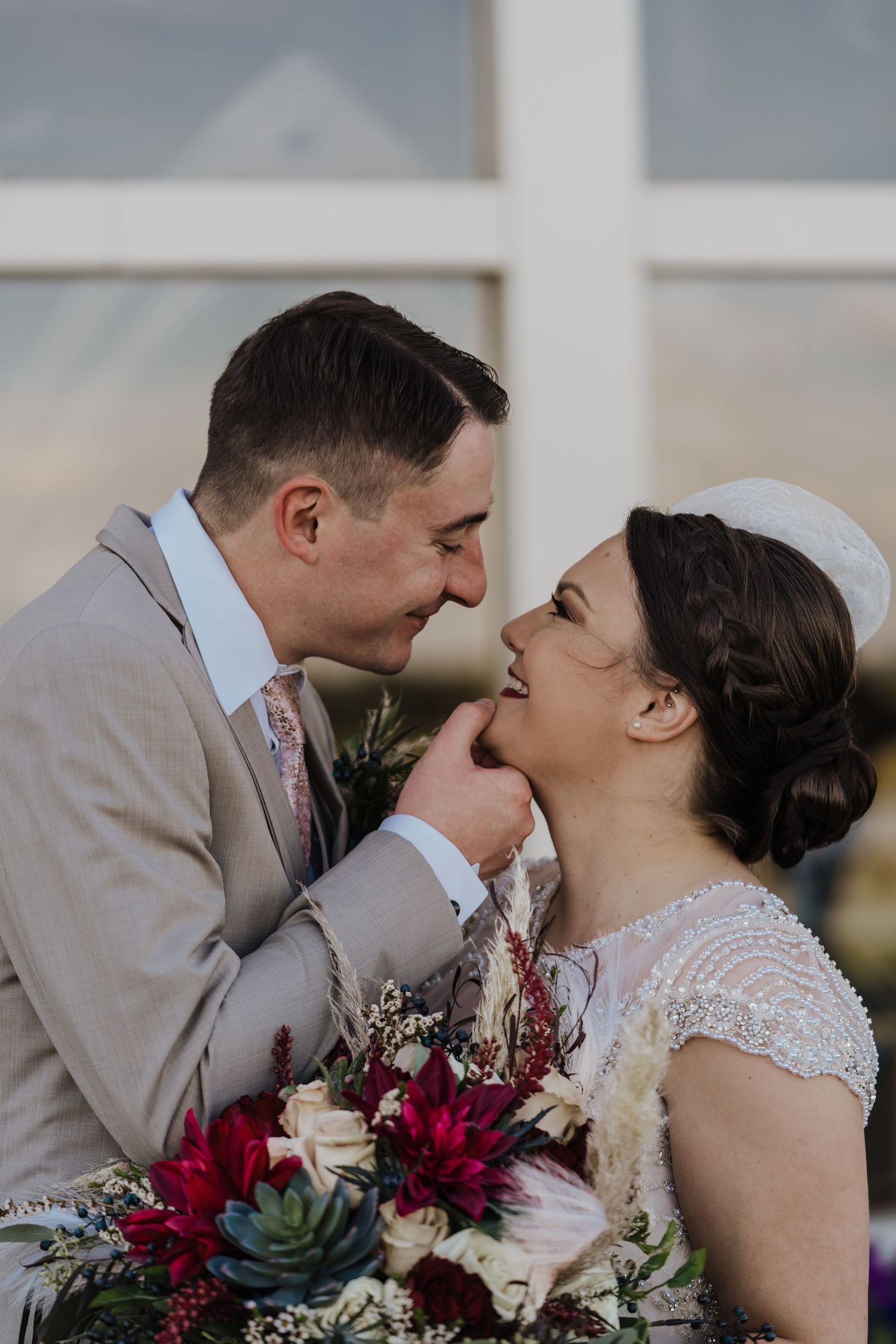 Groom lifting up brides face for a kiss