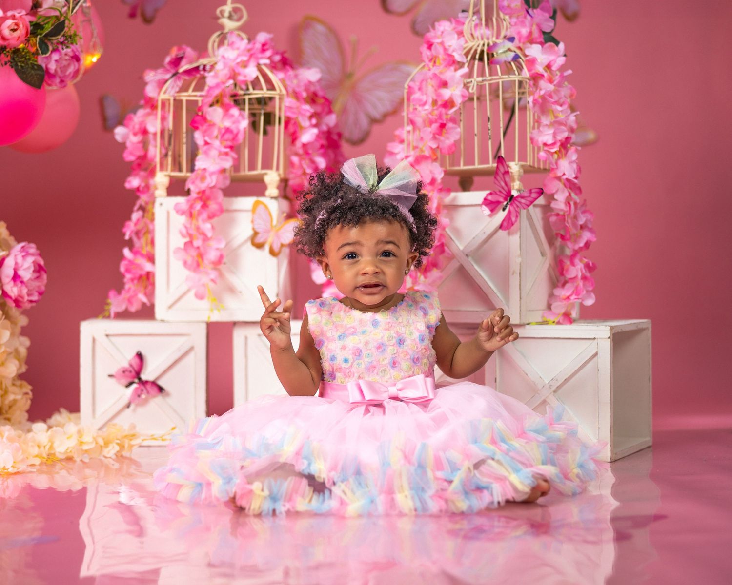 First birthday photoshoot with pink decor, bird cages, and floral arrangements.
