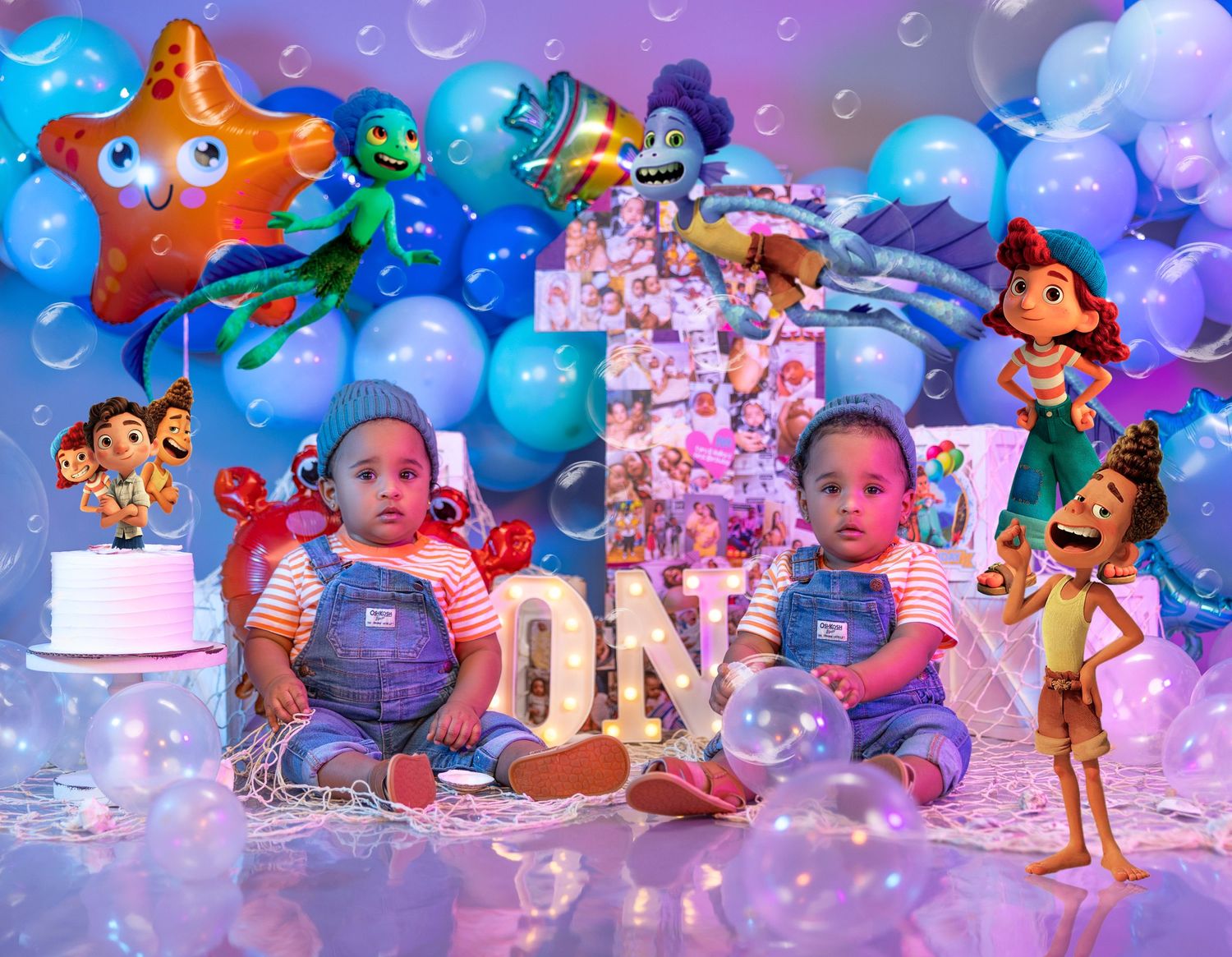 Twins first birthday with cartoon character decorations and blue balloon wall.