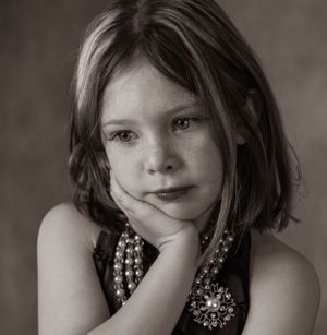 Artistic black and white portrait series showing expressive poses with pearl jewelry.