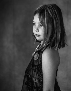 Dramatic black and white side profile portraits showing pearl necklace details.