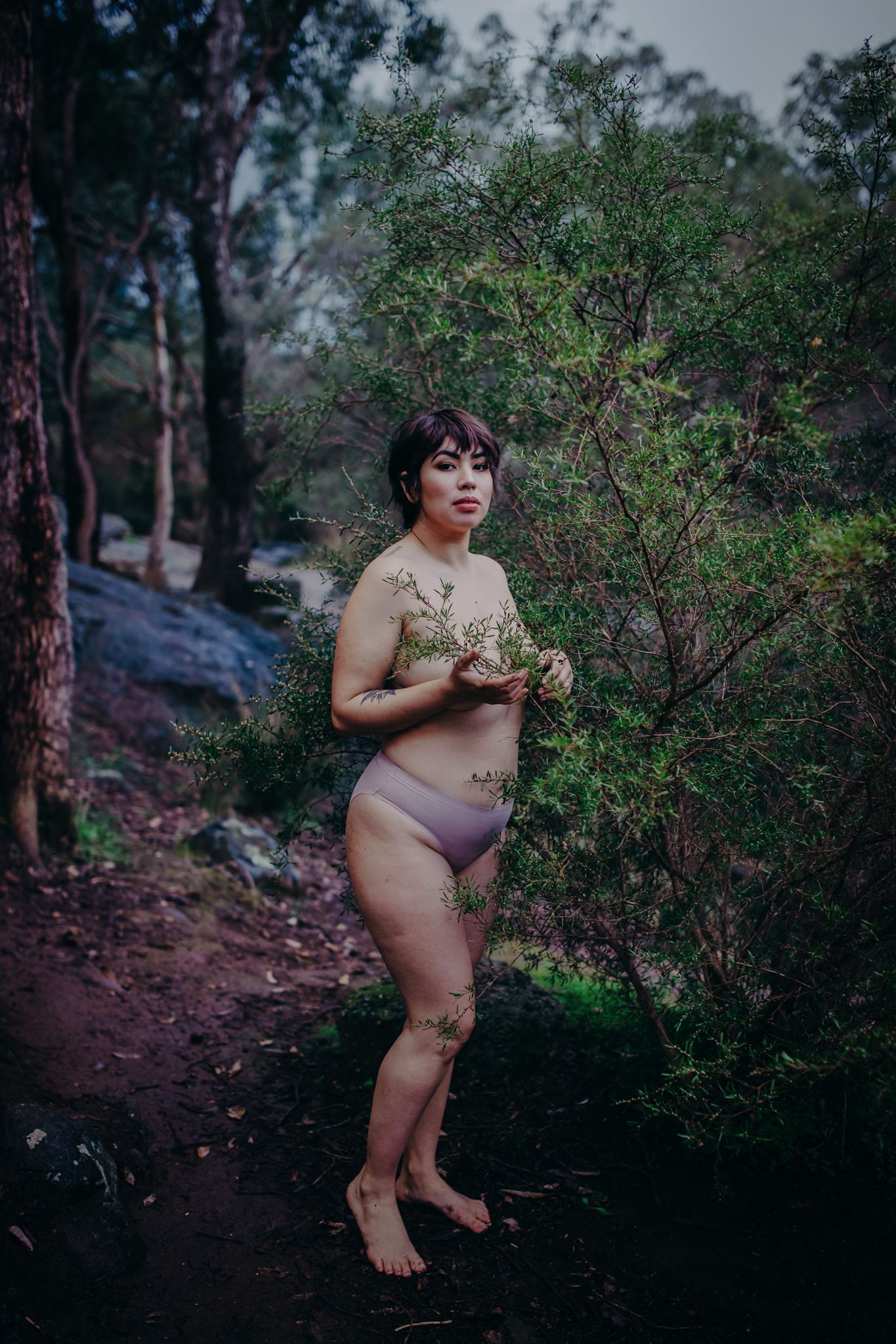 Ethereal outdoor boudoir photography on rocky terrain surrounded by native bushland.