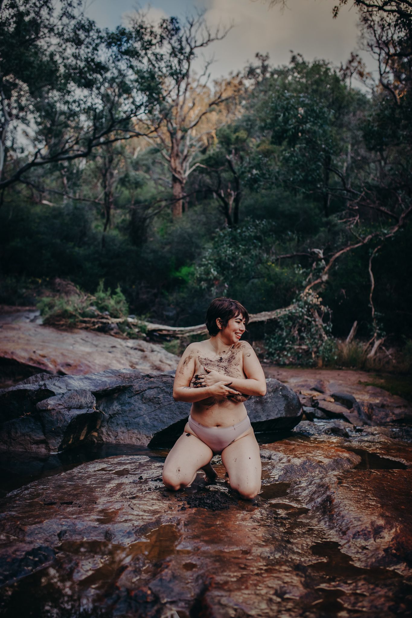 Intimate nature photography on red rocks beside a forest stream.