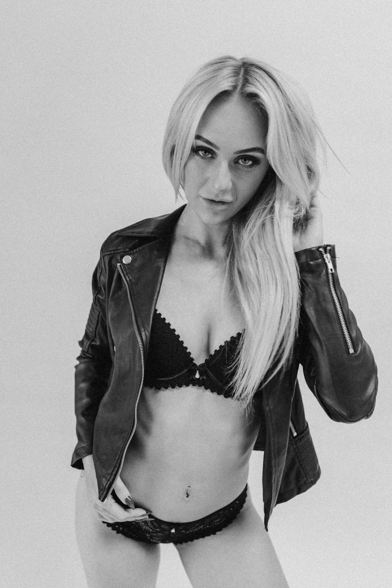Edgy contrast of leather jacket with lingerie in black and white studio shot.