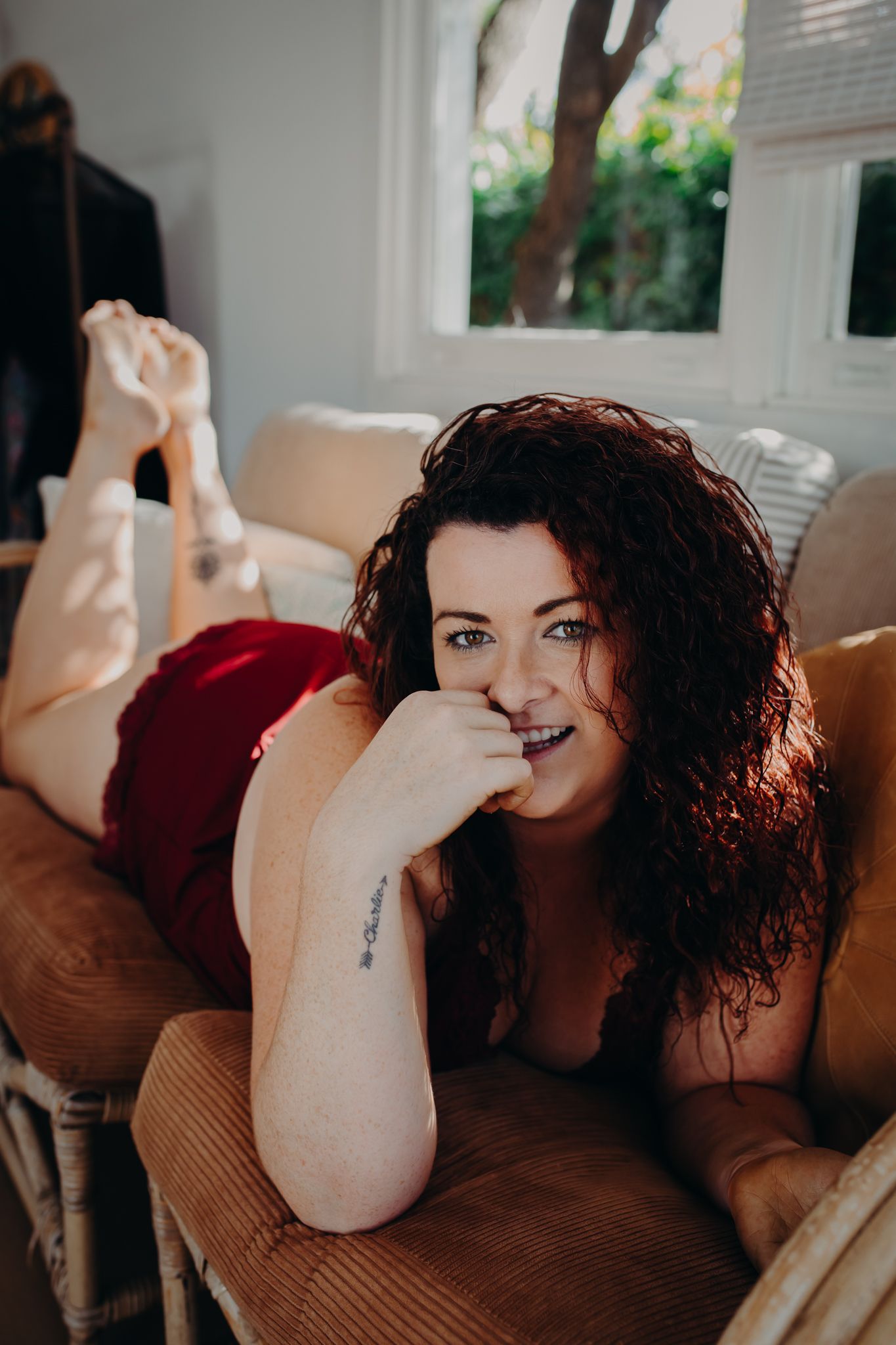 Candid indoor portrait on brown corduroy couch with natural window light.