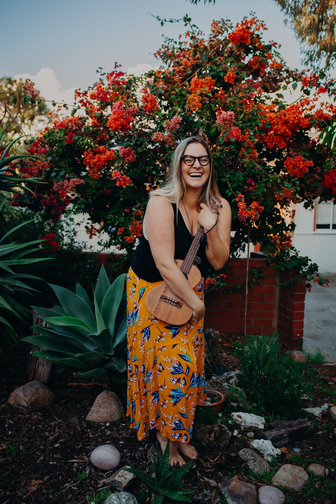 Candid garden portrait with blooming red flowers and musical instrument.